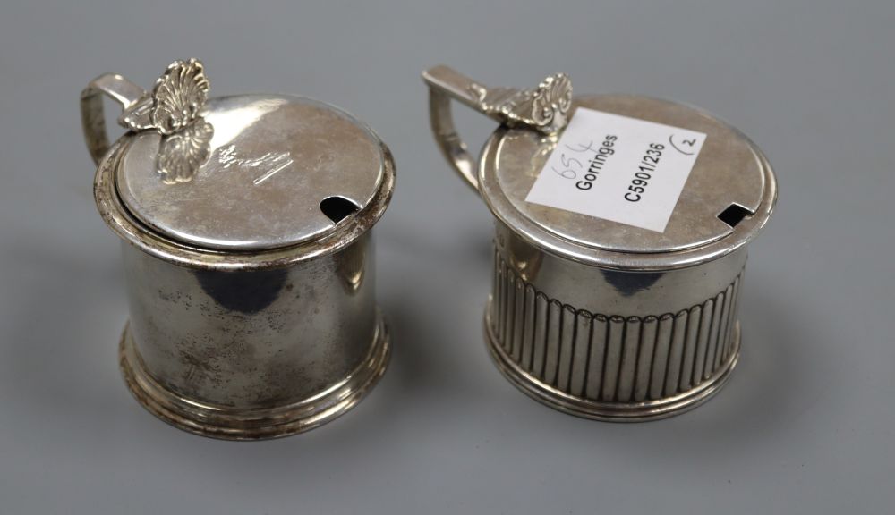 Two 19th century silver drum mustards, with blue glass liners. London, 1826 and London, 1853, tallest 7cm, 9oz.
